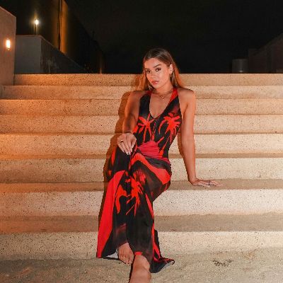 The Bachelorette Hailee Steinfeld took a picture in a classy black and red dress on a staircase.